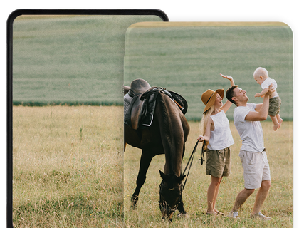E-Reader with a photo prints. The front print features a family outdoors in a grassy field with a horse: a man holds a baby in his arms, a woman in a tan hat stands beside them, and the horse is saddled and grazing.