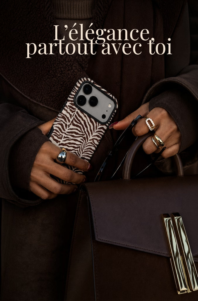 A person in a dark brown coat holds a zebra-print phone case and a dark brown structured handbag with gold-tone hardware. French text at the top reads 'L'élégance partout avec toi'.
