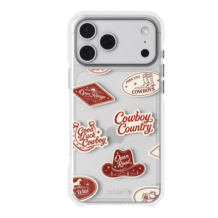 A clear protective phone case for a triple-camera smartphone, decorated with various red and cream western-themed stickers including cowboy hats, boots, and phrases like 'Cowboy Country' and 'Open Range'. The brand name 'KaseMe' is printed in small letters at the bottom of the case.